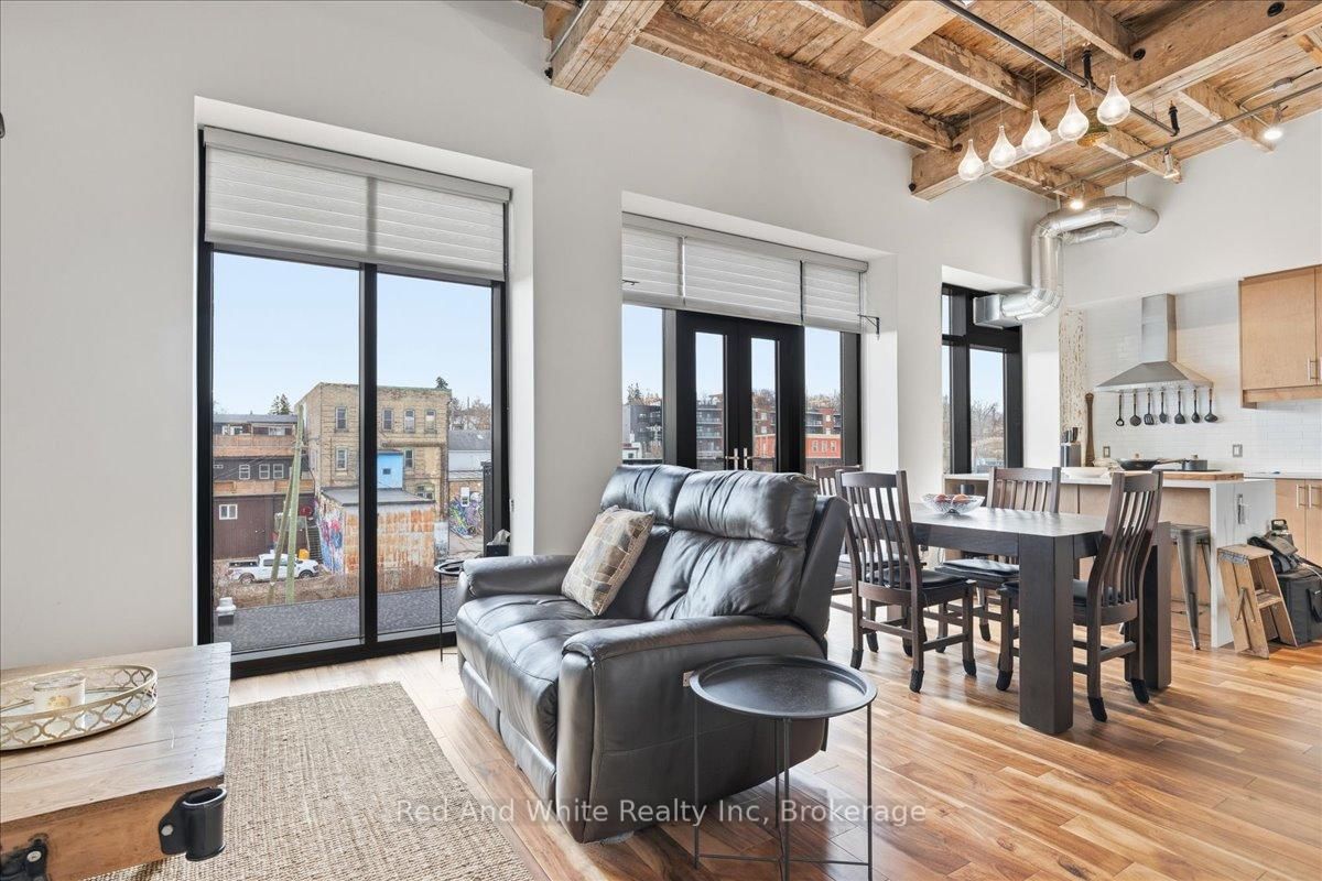 Welcome to Riverbank Lofts, one of Cambridge's most iconic and architecturally rich residences where historic industrial character meets refined, modern luxury along the banks of the Speed River. Set within the landmark former American Standard factory, thoughtfully transformed in 2020, this boutique building offers a truly unique ownership opportunity in the heart of downtown Hespeler, just steps to charming cafés, restaurants, trails, and vibrant community life. This exceptional one-bedroom residence is defined by its dramatic scale and design. Soaring 12-foot ceilings and striking floor-to-ceiling windows create an airy, light-filled space, while exposed stone walls and reclaimed wood beams add warmth, texture, and unmistakable character rarely found in today's market. The open concept living space is both elegant and functional, seamlessly connecting to a beautifully appointed kitchen featuring quartz countertops, stainless steel appliances, and an oversized island with breakfast bar ideal for entertaining or relaxed everyday living. Step out to your private balcony and take in the charm of downtown Hespeler, a perfect extension of your living space. The spacious bedroom offers a serene retreat, complete with a generous walk in closet, while in suite laundry and thoughtfully designed finishes throughout enhance comfort and convenience. Residents of Riverbank Lofts enjoy access to an impressive collection of amenities, including a fully equipped fitness centre, multiple  lounges, bike storage, and a dedicated dog wash station curated to support a sophisticated, low maintenance lifestyle. Complete with an owned parking space and ideally located just minutes to Highway 401, this residence offers the perfect balance of tranquility, connectivity, and urban convenience. A rare opportunity to own a piece of Hespeler's history reimagined for modern living.  Builder floor plans 831 sq. ft plus balcony 40 sq. ft, laser  exterior 805.11 sq. ft. interior 648.65 sq. ft.